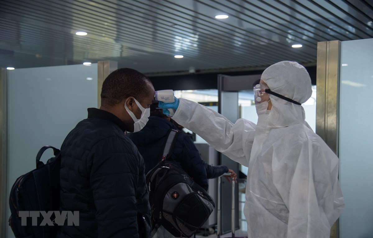 Nhân viên y tế kiểm tra thân nhiệt cho hành khách tại sân bay quốc tế Bình Nhưỡng, Triều Tiên ngày 9/3/2020. (Ảnh: AFP/ TTXVN)
