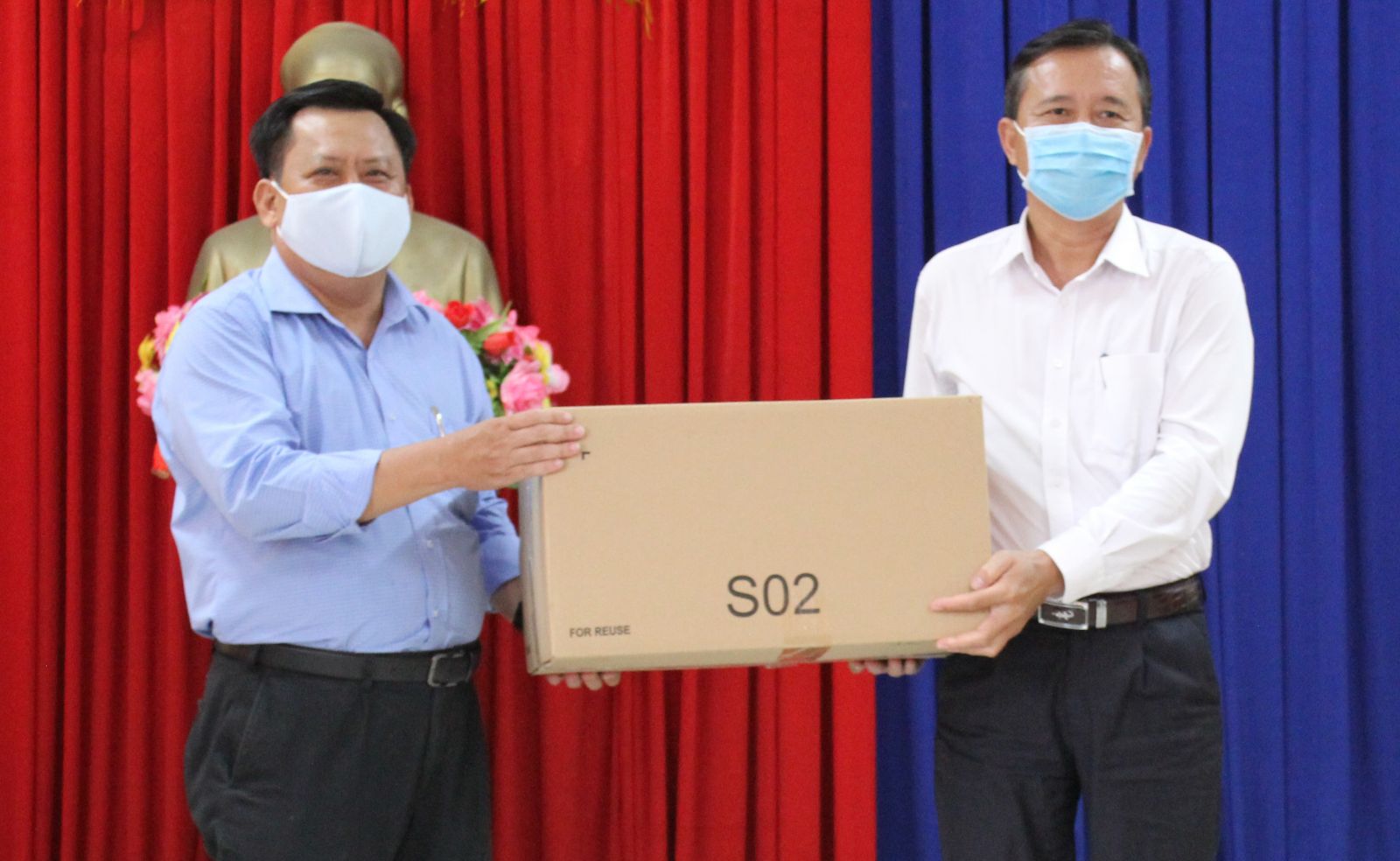Giám đốc Sở Kế hoạch và Đầu tư - Huỳnh Văn Sơn (bên trái) trao 4.000 khẩu trang cho Phó Chủ tịch UBND TP. Tân An - Nguyễn Quang Thái