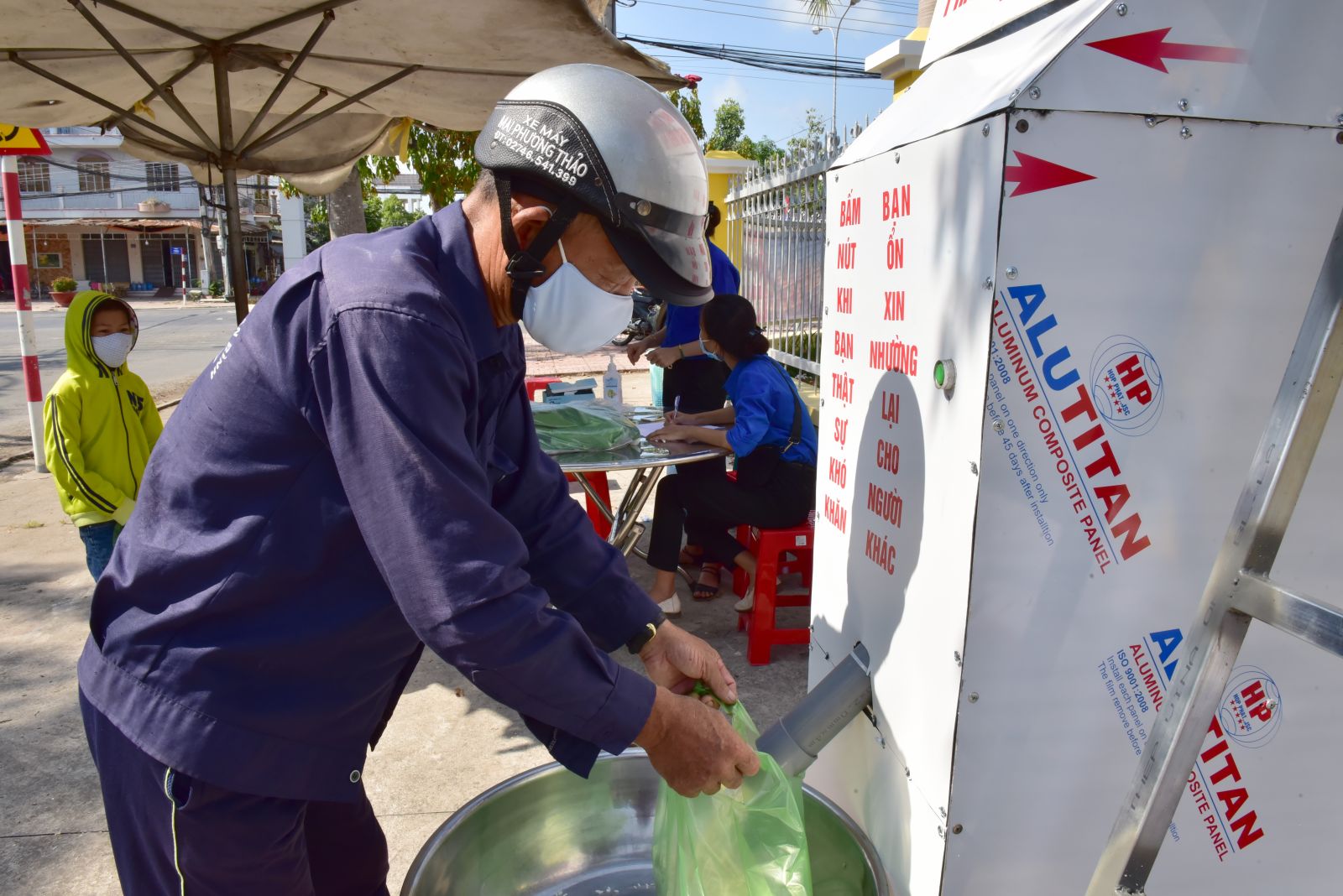 Người dân đến nhận gạo tại "ATM gạo" ở thị trấn Tân Hưng