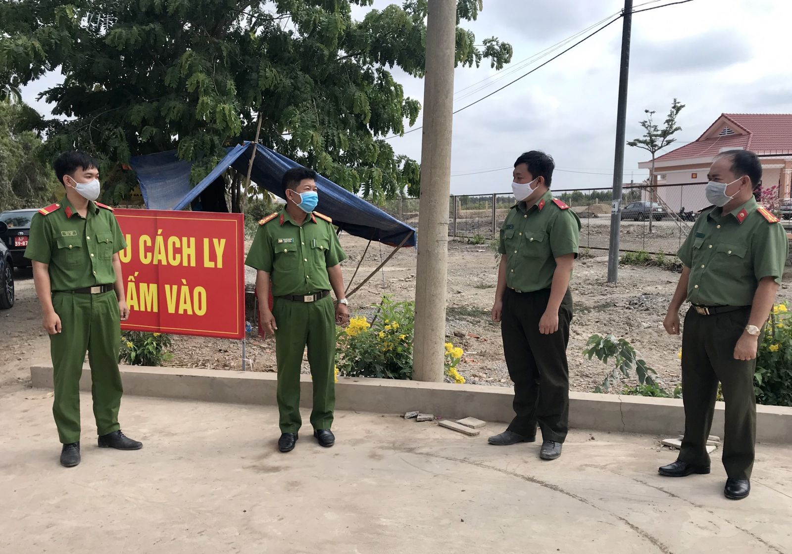 Đại tá Nguyễn Văn Hòa - Phó Giám đốc Công an tỉnh (thứ 2, trái qua) và Thượng tá Nguyễn Minh Sáng - Trưởng phòng Tham mưu Công an tỉnh (bìa phải) thăm cán bộ, chiến sĩ làm nhiệm vụ tại cơ sở cách ly tập trung (huyện Mộc Hóa)