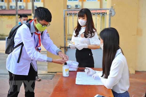 Học sinh trường trung học cơ sở Ninh Thành, tỉnh Ninh Bình sát khuẩn tay trước khi vào trường. (Ảnh: Minh Đức/TTXVN)