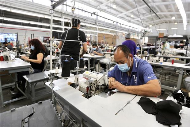 Công nhân làm việc tại nhà máy ở thành phố Vernon, Los Angeles, California, Mỹ ngày 16/4/2020. (Nguồn: THX/TTXVN)