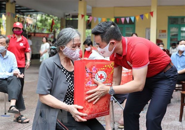 Cư dân có hoàn cảnh khó khăn nhận quà từ Hội Chữ thập đỏ Việt Nam (Ảnh: TTXVN)