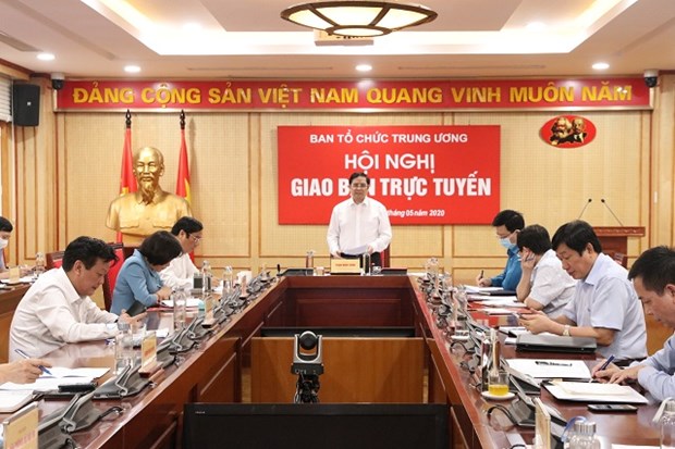 Party organization sector to press on with personnel preparations for all-level congresses Pham Minh Chinh (standing), Politburo member and Chairman of the Party Central Committee’s Organisation Commission, speaks at the teleconference on May 5 (Photo: xaydungdang.org.vn)