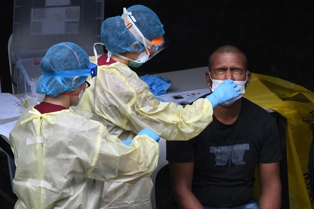 Nhân viên y tế lấy mẫu xét nghiệm COVID-19 tại Singapore ngày 27/4. (Ảnh: AFP/TTXVN)