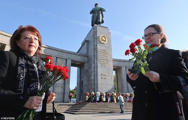 Người dân mang hoa tưởng niệm chiến thắng phátxít tại Berlin. (Nguồn: Reuters)