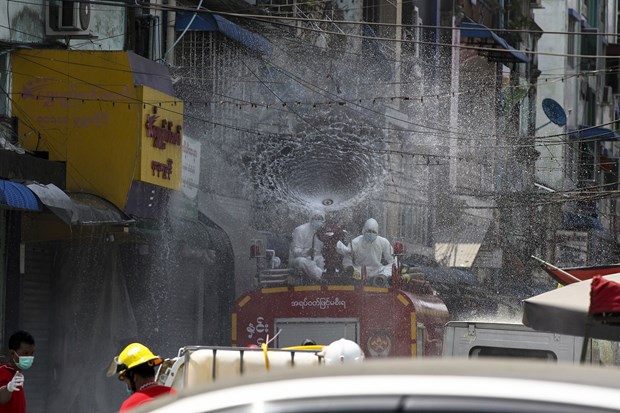 Myanmar military declares ceasefire for COVID-19 fight Members of Fire Service Department wearing full protective gear spray disinfectant from fire engine in hopes of curbing the spread of coronavirus on a street in Yangon, Myanmar (Photo: AP)