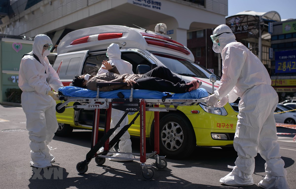 Nhân viên y tế chuyển bệnh nhân mắc COVID-19 vào một bệnh viện ở Daegu, Hàn Quốc. (Ảnh: AFP/TTXVN)