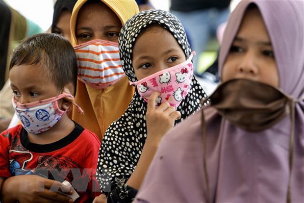 Phụ nữ và trẻ em đeo khẩu trang phòng dịch COVID-19 ở Blang Bintang, tỉnh Aceh, Indonesia. (Ảnh: AFP/TTXVN)