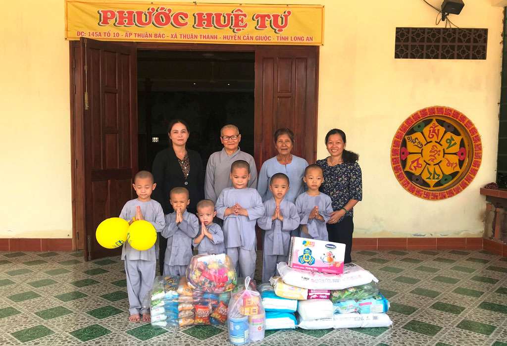 Chị Nguyễn Thị Ngọc Tuyết (bìa phải) đến thăm, tặng quà trẻ mồ côi trên địa bàn xã