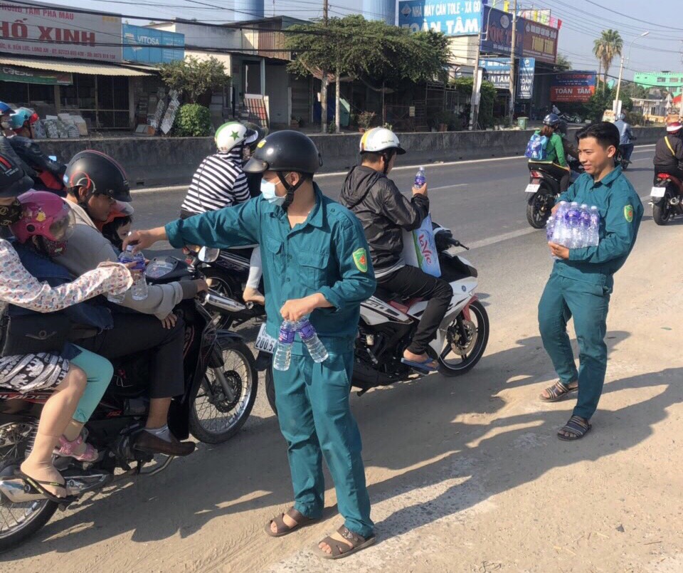 Hình ảnh đẹp của lực lượng dân quân tự vệ thị trấn Bến Lức hỗ trợ nước uống cho người dân về quê nghỉ tết