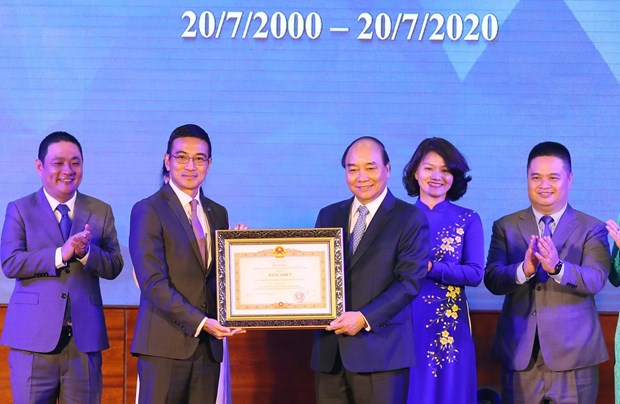 Stock market celebrates 20th birthday Prime Minister Nguyen Xuan Phuc (third, right) presents a merit certificate to the Ho Chi Minh Stock Exchange at the ceremony on July 20 (Photo: VNA)