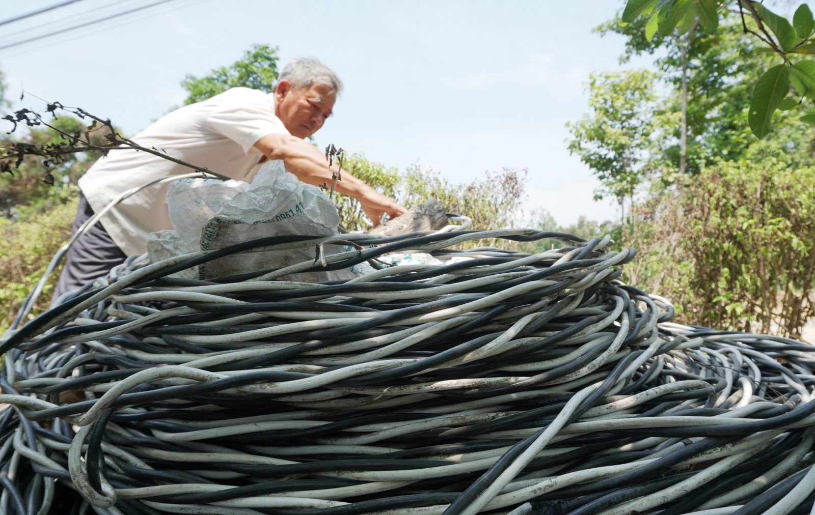 Ông Nguyễn Thanh Kiệt quấn dây điện để làm đường giao thông nông thôn