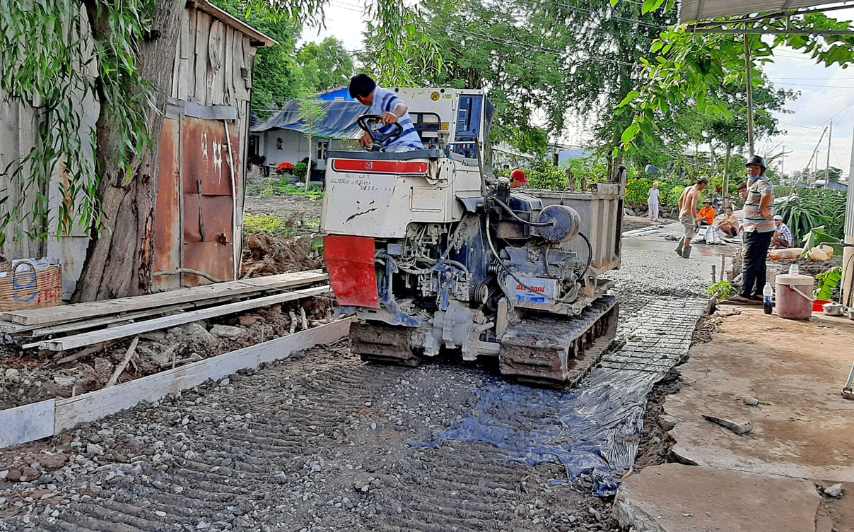 Không khí xây dựng quê hương không vì khó khăn trước mắt mà “giảm nhiệt” (Trong ảnh: Một công trình trải bêtông đường được thực hiện tại xã Phước Tân Hưng)