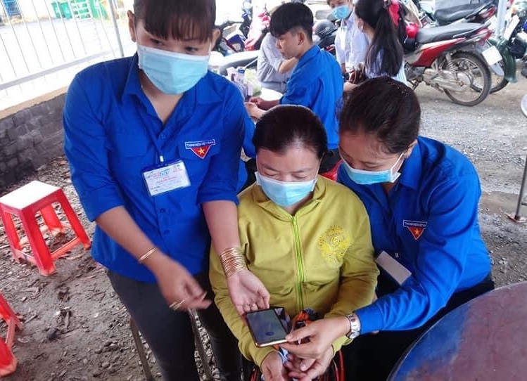 Đoàn viên thanh niên xã Lộc Giang, huyện Đức Hòa đang hướng dẫn cho người dân cài đặt ứng dụng Bluezone. Ứng dụng sẽ giúp cảnh báo cho người dùng về khả năng lây nhiễm Covid-19