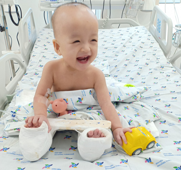 Cầm đồ chơi trên tay, Diệu Nhi cười tít mắt với bố mẹ và y bác sĩ - Ảnh: Bệnh viện cung cấp