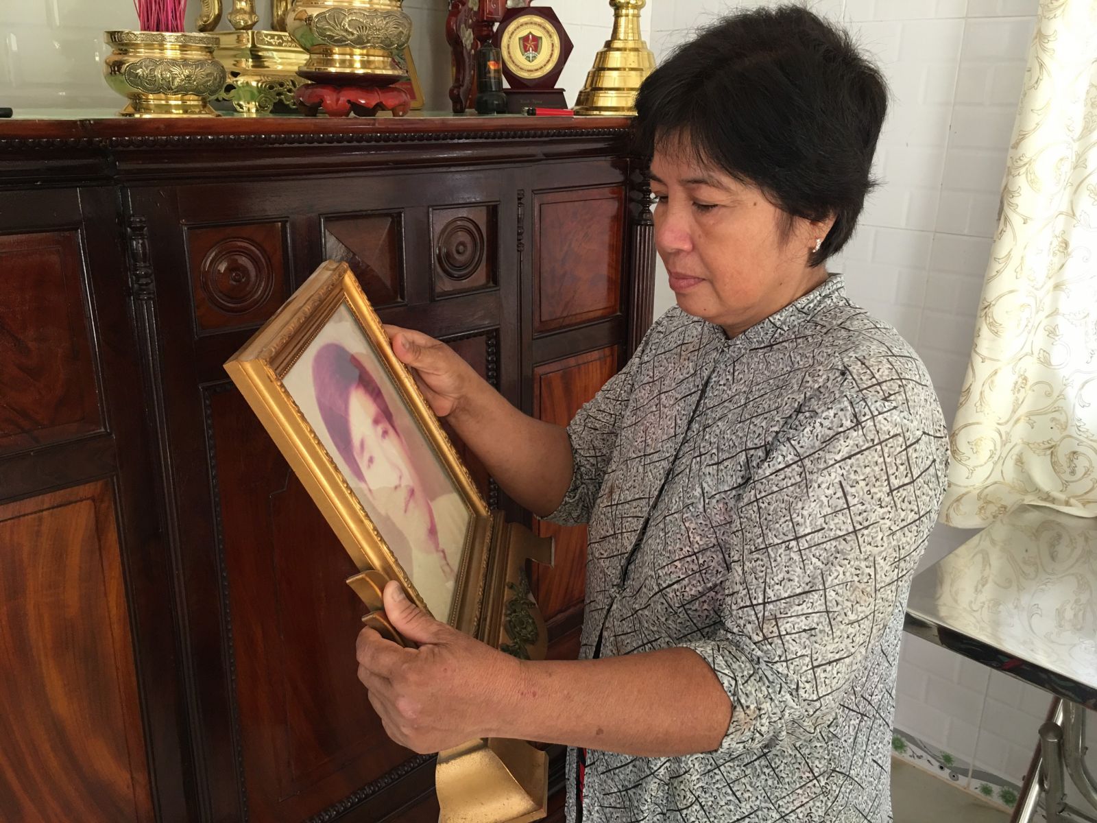 Bà Nguyễn Thị Tám ngắm nhìn di ảnh về người chồng đã hy sinh