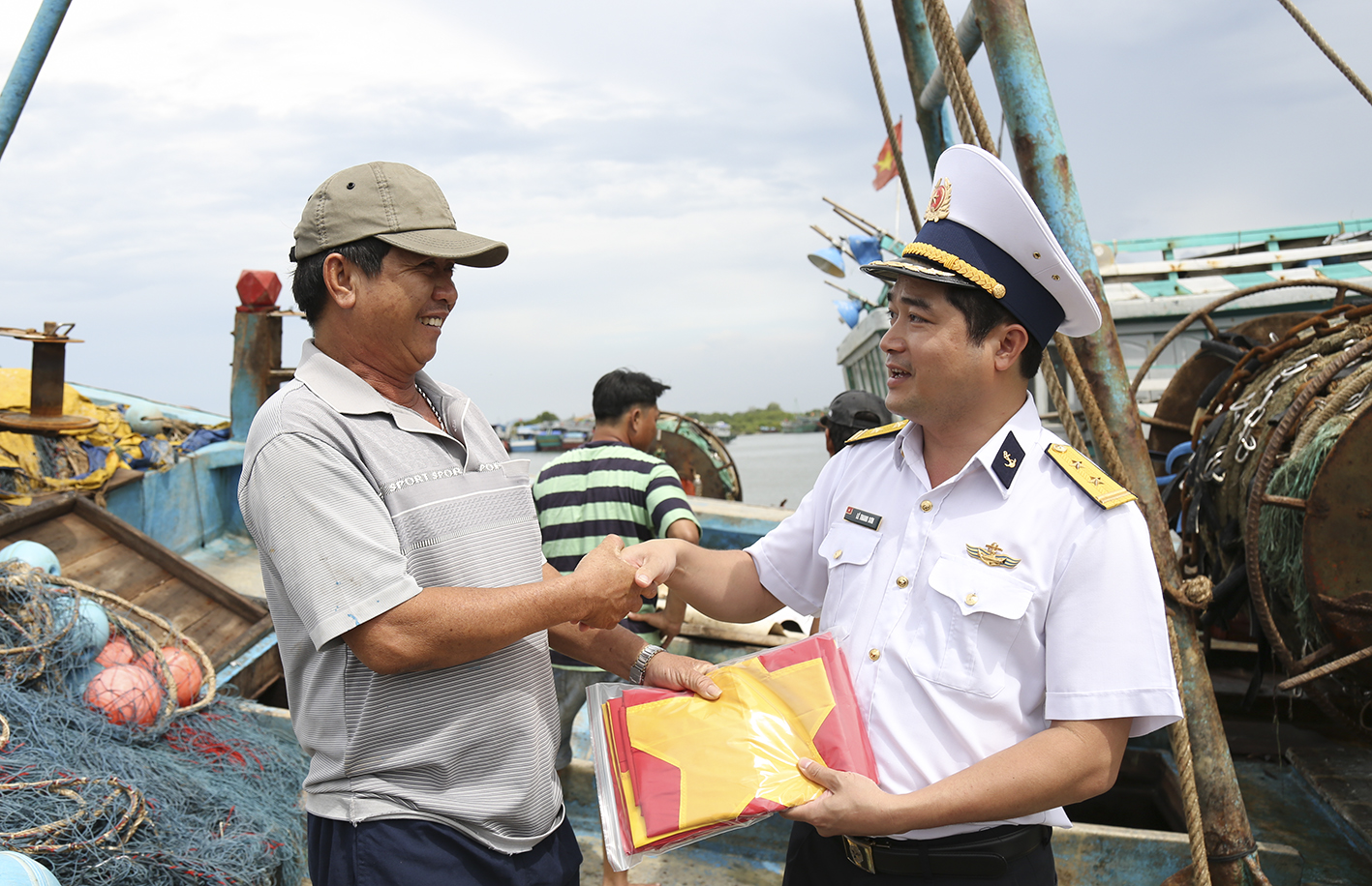 Trung tá Lê Thanh Sơn - Trưởng phòng Kinh tế Hải quân, tặng cờ Tổ quốc cho ngư dân trên tàu cá tỉnh Bà Rịa - Vũng Tàu