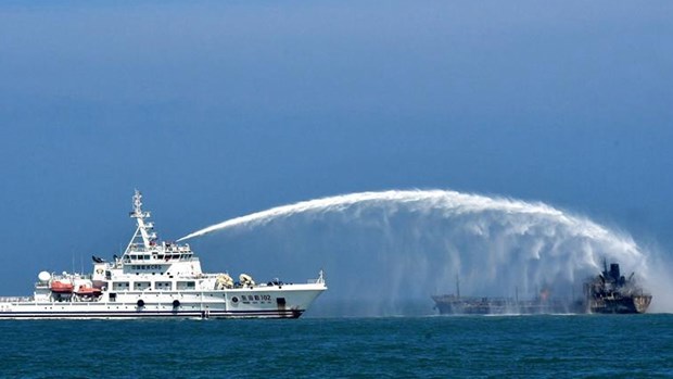 Tàu cứu hộ nỗ lực dập đám cháy sau vụ tàu chở dầu đâm tàu hàng. (Nguồn: Xinhua)