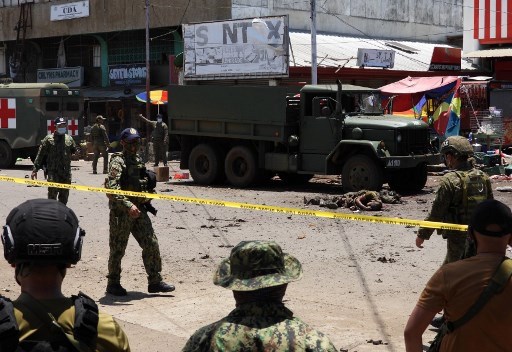 At least 15 people killed in Philippine blasts The bodies of victims (center) lie on the pavement as police and military personnel cordon off the site where an improvised bomb exploded next to a military vehicle in the town of Jolo, Sulu province on the southern island of Mindanao on August 24 (Photo: AFP)