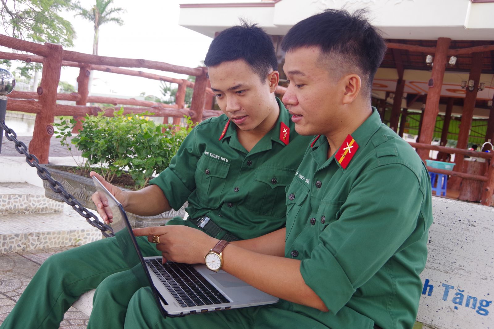 Trung sĩ Hồ Minh Vương (bên phải) và binh nhất Huỳnh Trọng Hiếu cùng trao đổi, hỗ trợ kiến thức ngoại ngữ và công nghệ thông tin với nhau