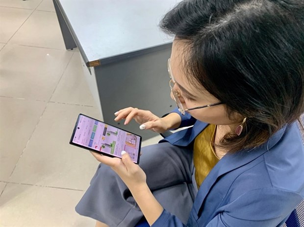 More Vietnamese consumers now shop online A woman browses an e-commerce website on her phone (Photo: VNA)
