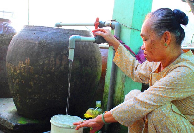 Long An: 65 pct. of rural households to access clean water by 2025 Local woman uses clean water (Source: baolongan.vn)