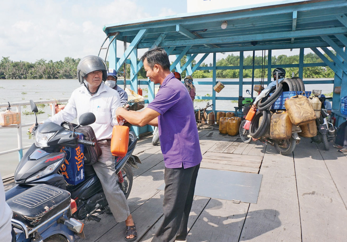 Thuyền trưởng Châu Bảo Đức nhắc nhở hành khách sử dụng dụng cụ cứu sinh cầm tay khi qua phà Vàm Thủ