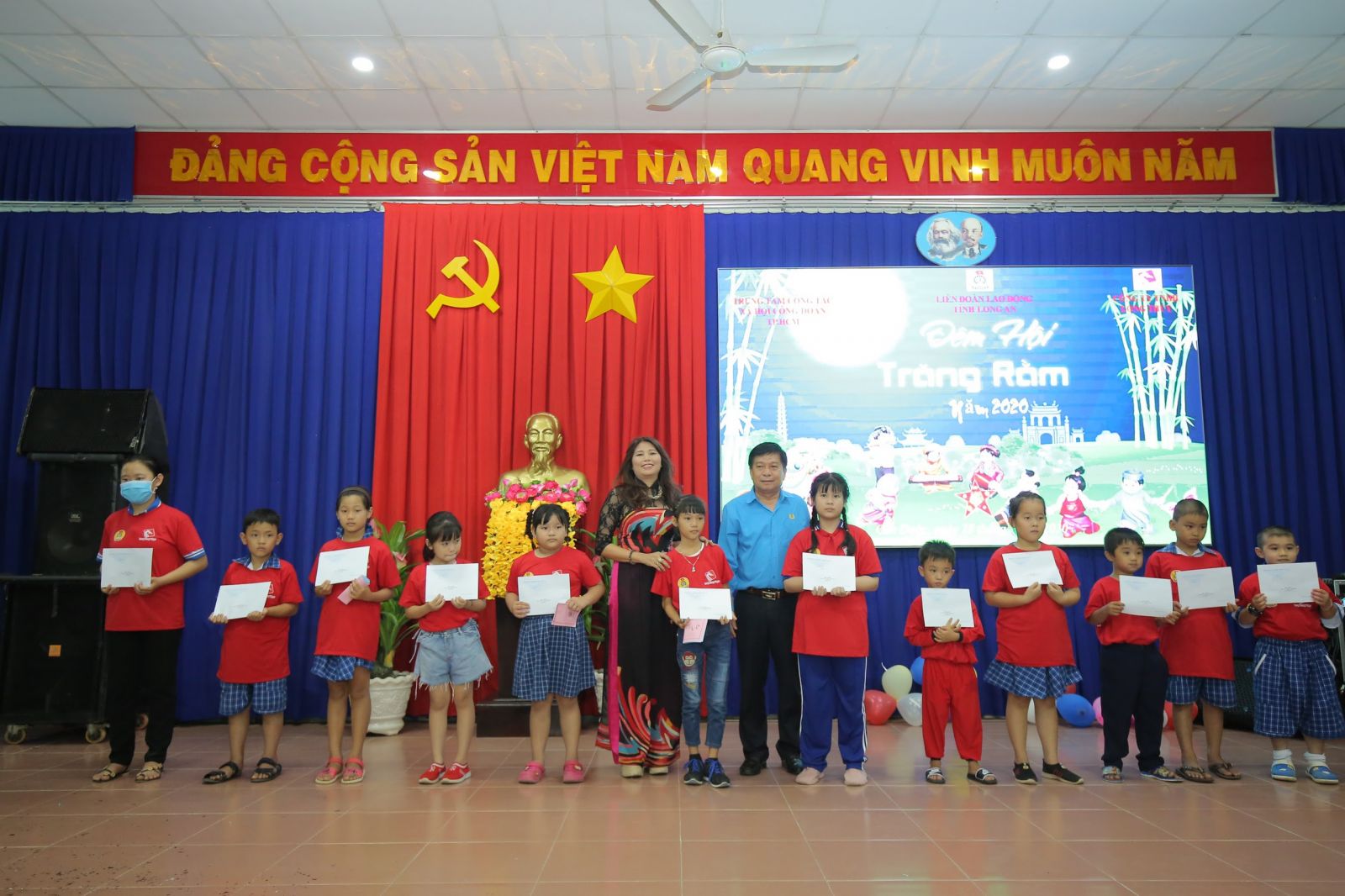 Chủ tịch Liên đoàn Lao động tỉnh - Nguyễn Văn Quí cùng đại diện nhà tài trợ trao tặng học bổng cho con công nhân, lao động nghèo vượt khó học giỏi