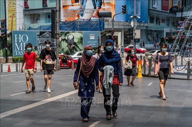 Malaysia holds urgent meeting over spike in COVID-19 infections People wear masks in Kuala Lumpur (Photo: AFP/VNA)