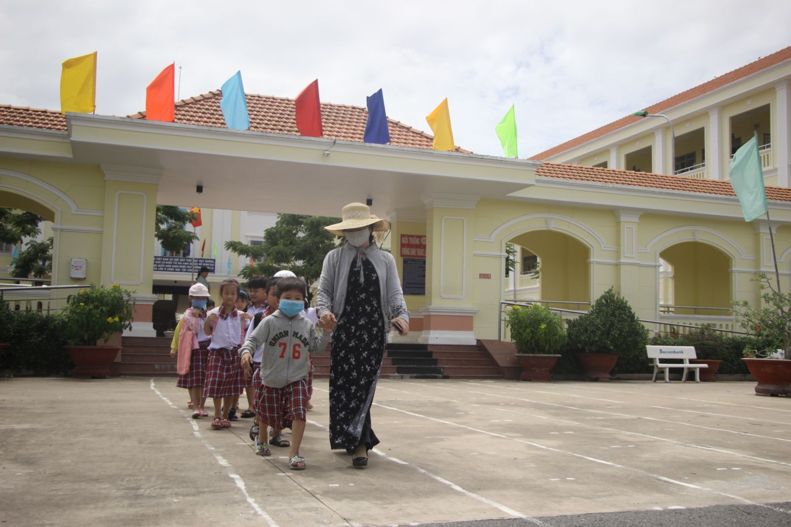 Giáo viên Trường Tiểu học Thị trấn Thủ Thừa đưa học sinh ra cổng theo lối đi kẻ sẵn