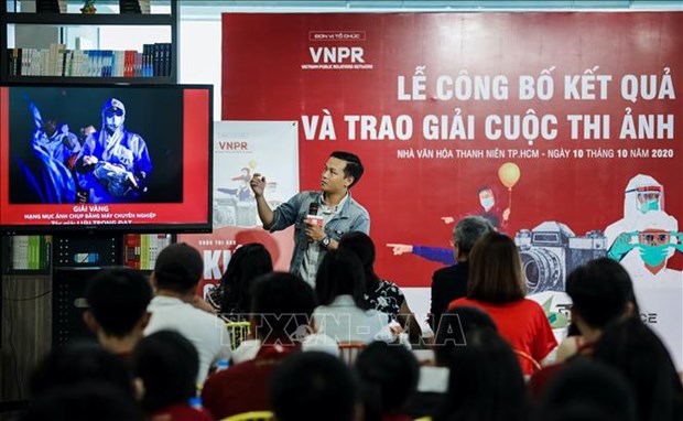 Photographer Luu Trong Dat from the Vietnam News Agency presents his Gold Prize photo in the professional photo category during the award ceremony. (Photo: VNA)