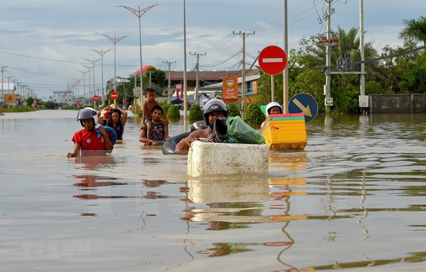 People evacuate from flooded area in Phnom Penh (Photo: AFP/VNA)