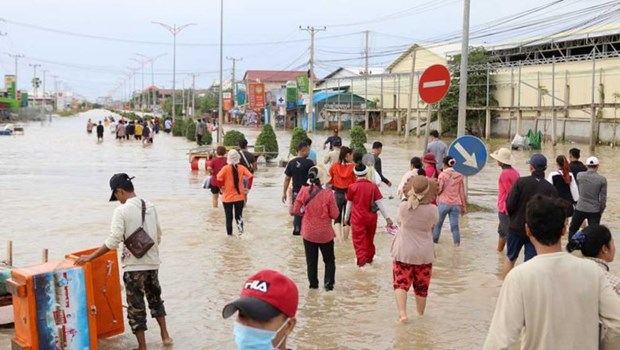 Workers wading through flooded streets in Phnom Penh’s Dangkor district. (Photo: The Phnom Penh Post)