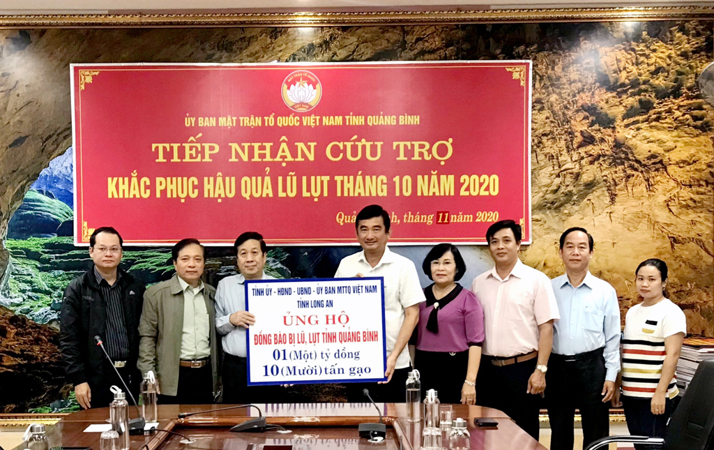 Vice Chairman of the Long An People's Committee - Pham Van Canh (5th, R) hands over a symbolic board of money and gifts to Quang Binh
