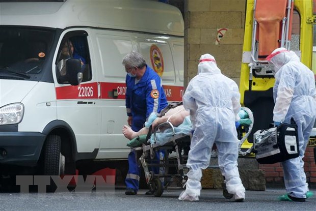 Nhân viên y tế chuyển bệnh nhân nhiễm COVID-19 tới bệnh viện ở Saint Petersburg, Nga. (Nguồn: AFP/TTXVN)