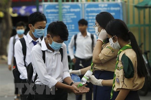 Cambodia bans mass gatherings, Thailand tightens border security Cambodian students wash their hands with santinizers before entering class (Source: AFP/VNA)