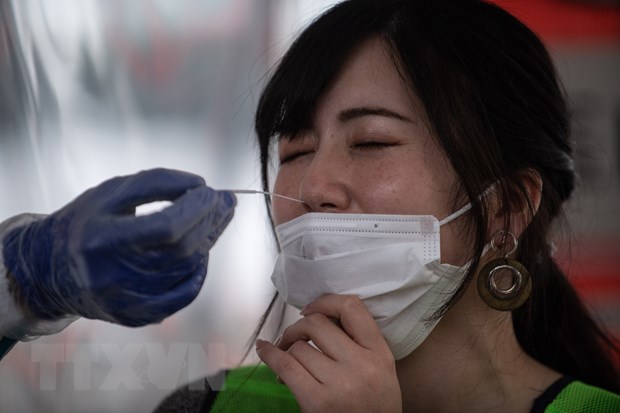 Nhân viên y tế lấy mẫu xét nghiệm COVID-19 cho người dân tại Kanagawa, Nhật Bản. (Ảnh: AFP/TTXVN)
