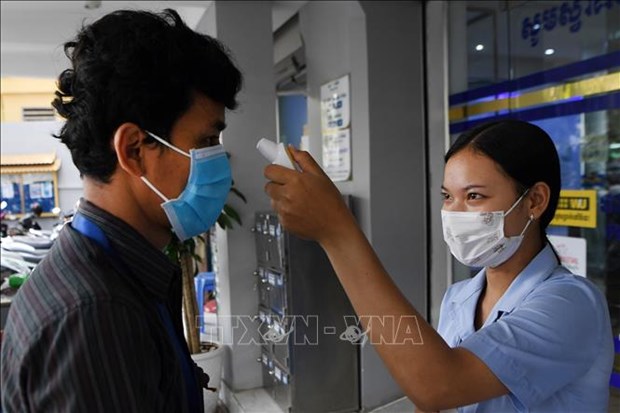 Cambodian PM orders health measures at business facilities Body temperature measurement outside a bank in Cambodia (Photo: AFP/VNA)