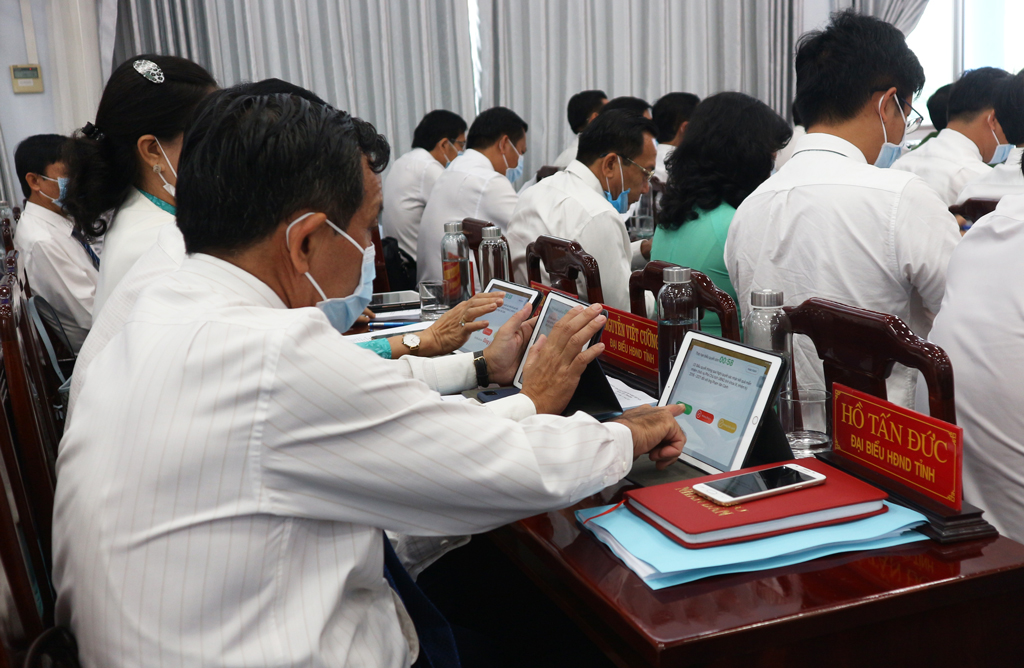 Delegates of the Provincial People's Council vote to approve the meeting agenda