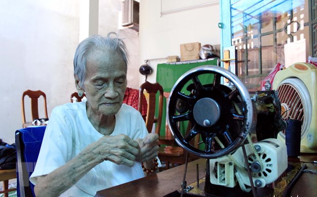 Mẹ Việt Nam Anh hùng Ngô Thị Quýt may hàng trăm khẩu trang hỗ trợ người nghèo phòng, chống dịch bệnh COVID-19. (Ảnh: TTXVN phát)