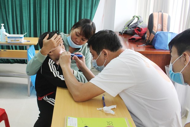 Free surgeries to bring smiles for children with cleft lips, palates A doctor gives check-up to a child under the cleft lip and palate surgery programme in Dak Lak province (Photo: VNA)