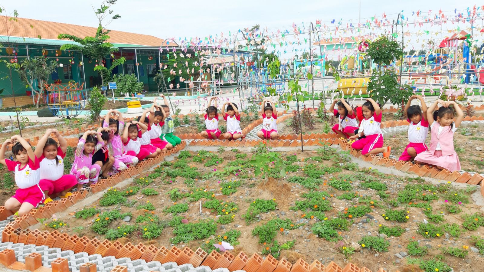 Mỗi ngày, vào giờ hoạt động ngoài trời, học sinh Trường Mẫu giáo Long Định được giáo viên cho ra vườn hoa và vườn rau của trường (ảnh nhân vật cung cấp)