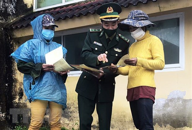 Bộ đội biên phòng tỉnh Thừa Thiên - Huế phát tờ rơi tuyên truyền về phòng, chống dịch COVID-19. (Ảnh: TTXVN phát)