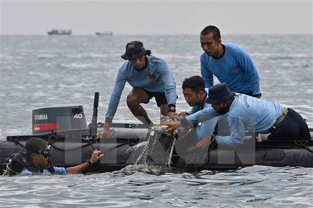 Condolences sent to Indonesia over plane crash Divers from the naval force search for plane debris from the crash in the waters near Lancang Island, Indonesia, on January 10. (Photo: AFP/VNA)