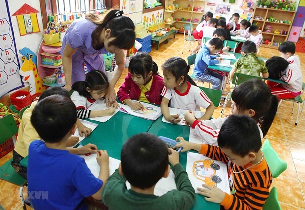 Action programme to promote all-round development of children Children at a kindergarten class (Photo: VNA)