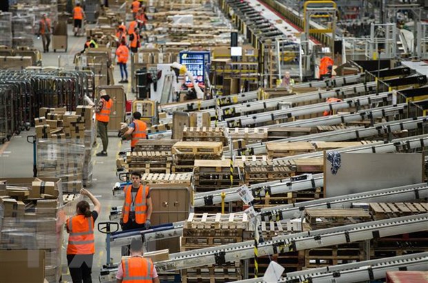 Nhân viên chuẩn bị hàng hóa theo đơn yêu cầu của khách hàng tại trung tâm phân phối hàng của Amazon tại Peterborough, miền Trung Anh. (Ảnh: AFP/TTXVN)