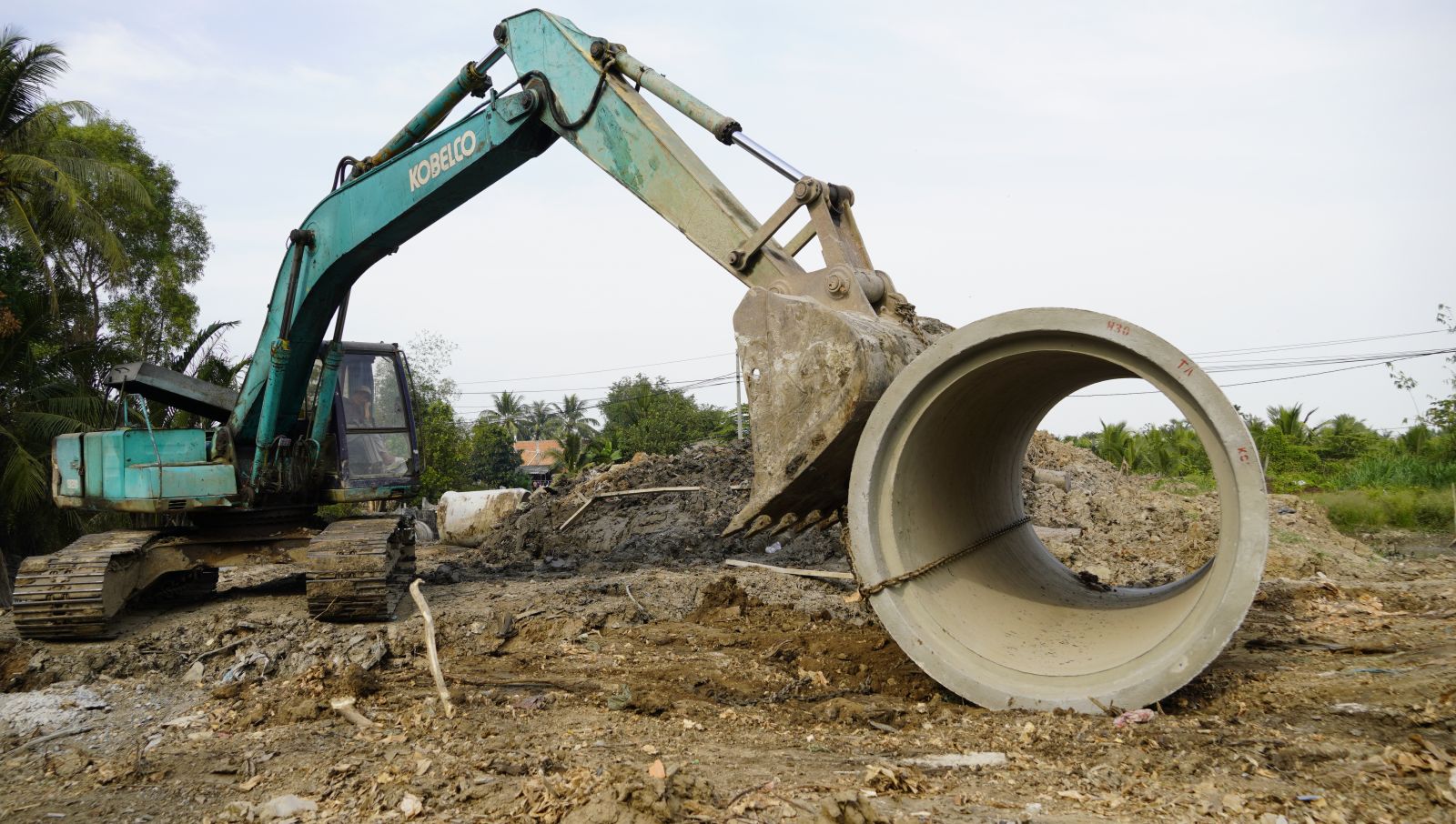 Ring Road of Tan An city: Arterial road for development Trucks are moving the sewer pipe to install into the sewer system from a canal running across Ring Road in Loi Binh Nhon commune