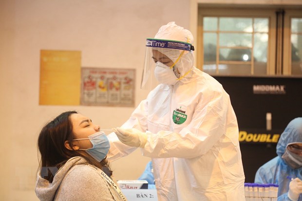 Nhân viên y tế lấy mẫu dịch mũi xét nghiệm SARS-CoV-2 cho người dân. (Ảnh TTXVN phát)