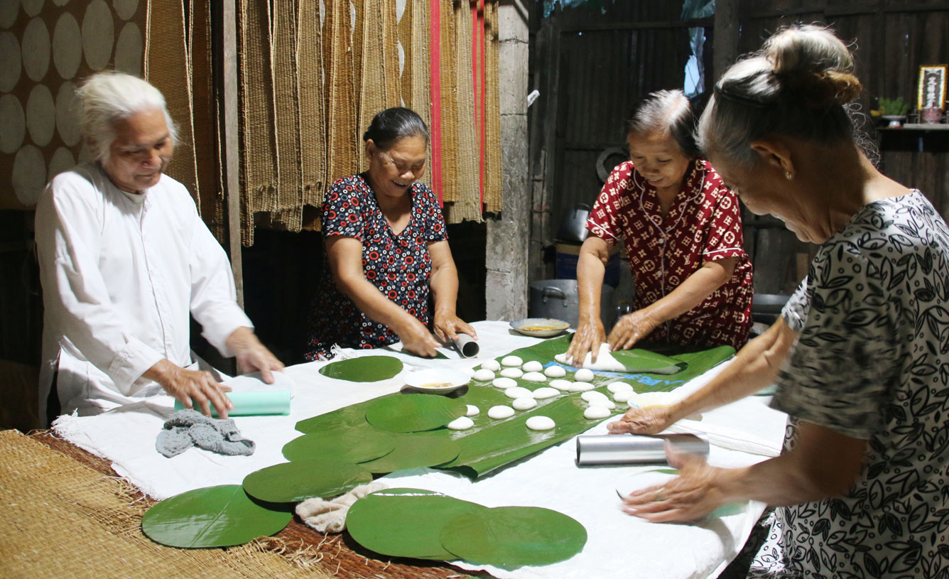 Trời tối muộn, các bà, các bác tập trung đông đủ làm bánh để kịp đem phơi vào buổi sớm mai